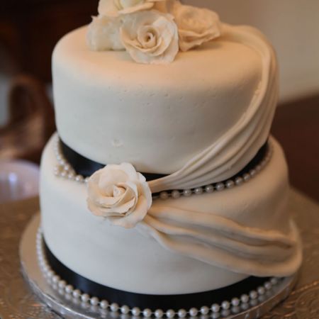 Tiered Summer Wedding Cake with Black Ribbon and Cascading fabric with Rose Accents