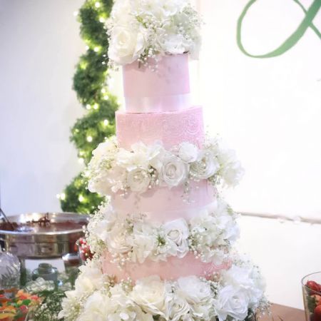 Pink Wedding Cake with lush white flowers by Remnant Fellowship Cake Committee