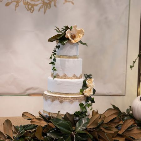 Mendl/Hayden Remnant Wedding Fall White tired Wedding cake with gold accents and magnolia greenery
