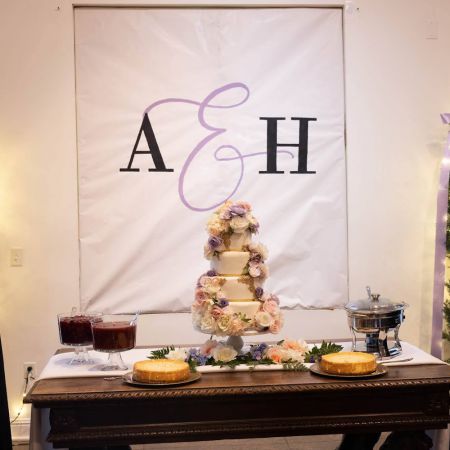 Four Tiered White Wedding cake with Cascading purple florals by the Remnant Fellowship Cake Committee
