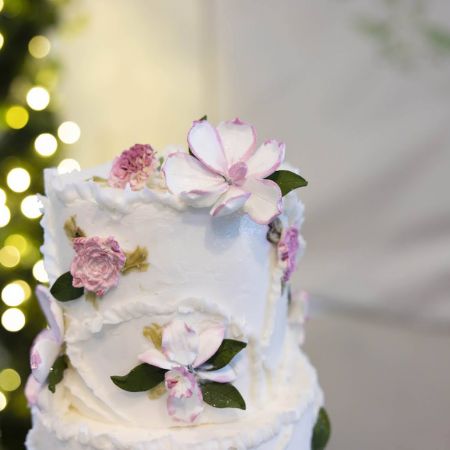 White Tiered Wedding cake with pink flower details and frosting designs by Remnant Fellowship Cake Committee