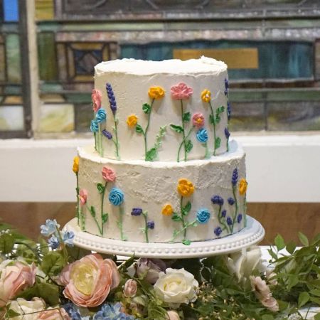 white two tiered wedding cake with pastel piped flowers made by the Remnant Fellowship Cake Committee