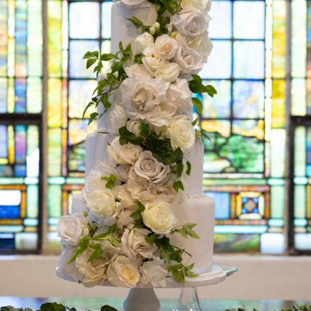 Rolfes/Parson Covenant Wedding Large White Wedding cake with Big beautiful white roses and greenery made by the Remnant Fellowship Cake Committee