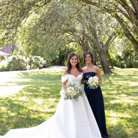 Rolfes/Parson Covenant Wedding Bridesmaid with a strapless navy long dress and white floral bouquet