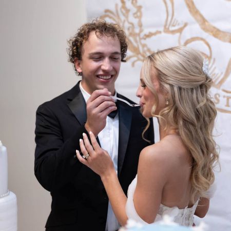 Stites/Shepherd Covenant Wedding Stites/Shepherd Remnant Fellowship Covenant Wedding Cake Cutting- White Wedding Cake with Intricate designs, white florals and gold monogram by Remnant Fellowship Cake Committee