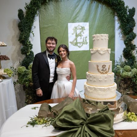 White Detailed Wedding Cake with detailed piping and gold monogram with gold laurel wreath
