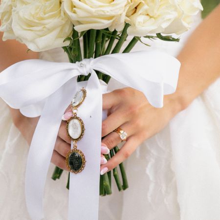White Rose Bouquet with a large white bow and a remembrance charm by The Remnant Fellowship Flower Committee