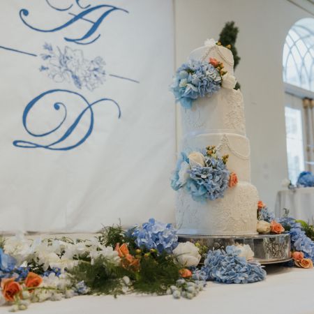 A Simple Three Tired White wedding cake with fancy piping and touches of light blue and coral