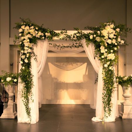 Martin/Hahn Covenant Wedding Wedding Chuppah draped in flowing white fabric with cascading greenery and white roses decorated by the Remnant Fellowship Decorating Committee