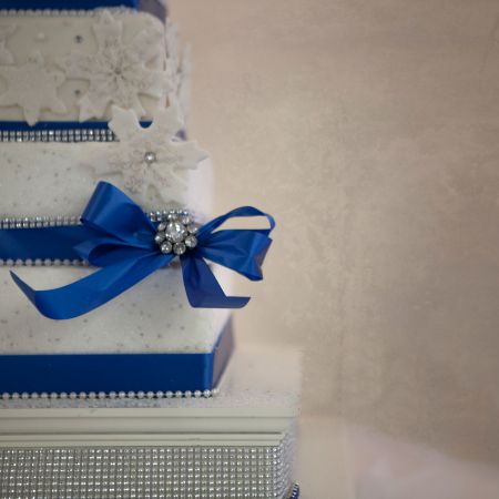 White Winter Wedding Cake | Square Tiered Wedding Cake with Cobalt Blue Ribbon and Powdered Sugar Snow